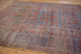 Distressed antique Belouch carpet border with geometric bursting plants and checkered design.
