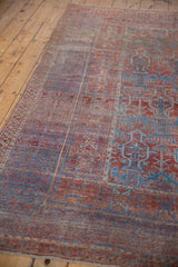 Distressed antique Belouch carpet showing geometric plants, partial vase motifs, red and indigo blue.