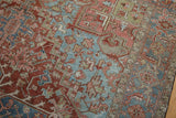 Vintage distressed Heriz carpet detail with brick red, powder blue, and visible wear.