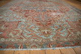 Vintage distressed Heriz carpet's geometric design in brick red and powder blue, with fringe.