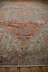 Worn cream fringe and geometric brick red, denim blue border of the vintage Heriz rug.