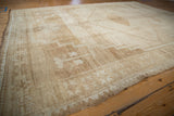 Distressed Kars carpet corner detailing geometric patterns, short pile, and original selvage in ivory, beige, and sand.