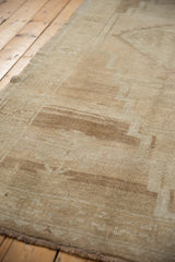 Distressed vintage Kars carpet pile texture, revealing abrashed beige and sand tones.
