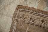 Textured ivory reverse and brown geometric patterned selvage of a vintage Kars carpet.