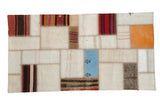 Vintage Turkish patchwork flatweave runner featuring ivory, blue, and striped kilim fragments.