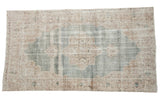 Vintage distressed Sparta carpet, faded denim blue field, ivory starburst medallion design.