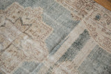 Close-up of distressed vintage Sparta carpet, showing wear, faded palmette patterns, pale blue, and ivory.