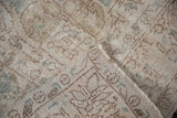 Distressed vintage Sparta carpet pile revealing knot heads, beige and blue tones, and fringed edge.