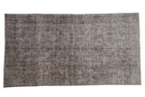 Distressed overdyed Turkish Sparta rug, charcoal field with faded sapphire blue and purple vinery.