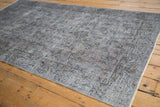 Distressed vintage Sparta rug showing faded charcoal, pale purple, and sapphire blue blossoms.