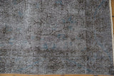 Overdyed vintage Sparta rug with distressed charcoal pile, faded sapphire blue vinery, and secure fringe.