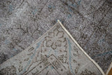 Distressed vintage Sparta rug with charcoal pile, sapphire blue hints, and exposed woven foundation.