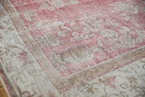 Distressed Sparta carpet corner with faded rose and ivory floral patterns, revealing foundation wear.