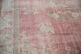 Soft rose blush and faded ivory floral motifs on distressed vintage Sparta carpet.