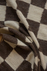 Textured weave of alternating ivory and chocolate brown geometric kilim squares.