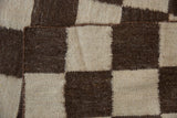 Hand-woven texture of alternating ivory and chocolate brown checkered blocks with an emulated Navajo weave.