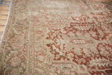 Distressed vintage Heriz carpet showing geometric arabesques and turtle border motif in deep red, beige.