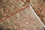Distressed vintage Heriz carpet showing geometric pile, hand-knotted back, and red side cording.