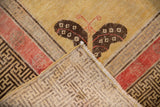 Antique Khotan rug corner, dark butterfly, geometric border, hand-knotted foundation.
