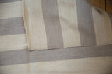 Hand woven ivory and oxidized silver stripes on Egyptian Kilim rug's flatweave texture.