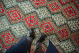 Vintage Afghani Kilim showcasing geometric gul and floral motifs in cherry red and teal.