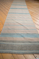 Hand woven Afghani Kilim texture showing varied pale blue, beige, and grey stripes.