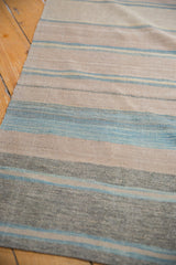 Handwoven Afghani Kilim with repeating blue, beige, and gray horizontal stripes.