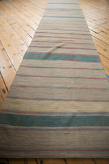 Hand woven Afghani Kilim runner, layered horizontal stripes in beige, dusty green, pale blue, and red.