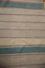 Hand-woven Afghani Kilim runner flatweave texture with beige, dusty green, and thin red stripes.