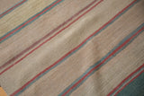 Close-up of hand-woven Afghani Kilim rug showing beige, red, and denim blue stripes.