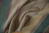 Layered teal, beige, red, and blue stripes of a textured hand-woven Afghani Kilim.