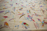 Embellished raised stitching creates colorful bird motifs on the flat ivory kilim weave.