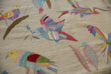 Raised stitching creates colorful pictorial birds atop a flat ivory kilim weave.