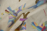 Detail of embellished raised stitching forming colorful birds on an ivory kilim carpet.