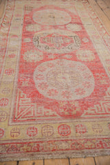 Fringe and pale gold wave border motifs of a vintage Khotan rug runner.