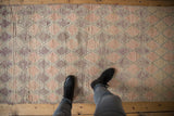 Distressed Moroccan runner's short pile, showing mauve, rose, ivory trellis and diamond pattern.