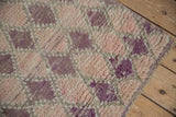 Original side cord selvage of a distressed Moroccan rug with purple and rose pile.