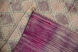 Distressed vintage Moroccan runner pile with subtle abrashes, revealing vibrant purple flatweave underside.