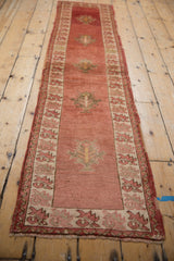 Tattered end fringe and distressed pile of a vintage Anatolian runner's serrated leaf border.