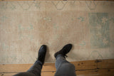 Distressed vintage Oushak runner showing abrashed ivory, beige, pale green trellis and floral pattern.