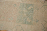 Distressed vintage Oushak runner close-up, revealing softened ivory and pale ocean green trellis with floral motifs.