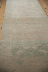 Texture of distressed vintage Oushak rug with abrashed ivory and pale green tones.