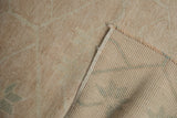 Distressed vintage Oushak rug with worn ivory pile, faded pale green pattern, and woven foundation.