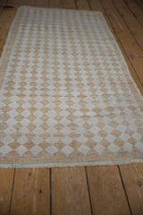 Distressed Oushak runner's staggered end, showing partial pawn motif and texture.