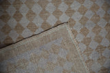 Distressed beige diamond pile of the Oushak rug with visible ribbed foundation and selvage.