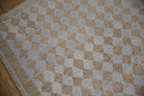 Distressed Oushak geometric diamond pattern in beige, pale mauve, faded blue with even wear.