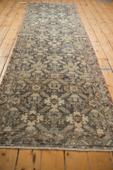 Distressed Malayer runner close-up reveals muted slate, ivory, brown palmette trellis pattern.