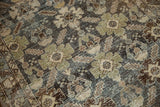 Distressed Malayer rug texture in muted green, slate, and ivory patterns.