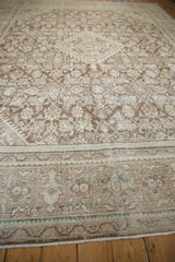 Distressed vintage Mahal carpet corner, showing worn pile with faded brown and ivory motifs.