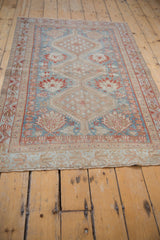 Distressed Afshar rug end with faded sky blue, madder red, and brown geometric patterns.